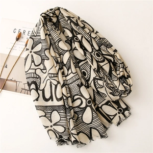 Detail of soft beige cotton linen scarf with elegant black floral and geometric prints