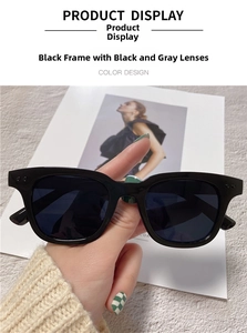Detail of black bold frame sunglasses with dark grey lenses and dual metal stud accents