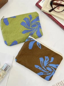 Floral canvas zipper pouch set for coins and makeup items on a white minimal desk