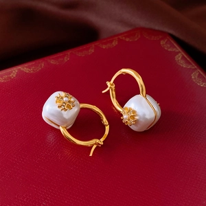 Détail de boucles d'oreilles en perles plaquées or 18 carats sur boîte à bijoux vintage rouge
