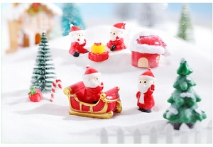 Miniature resin Santa Claus and reindeer sleigh set on artificial snow for micro landscape