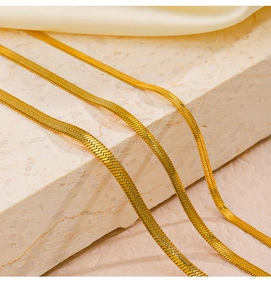 Flat snake bone chain bracelets in three widths on marble and silk background