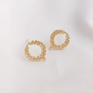 Close-up of 14K gold-plated wreath ear studs with detailed wheat leaf textures