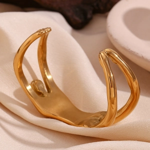Detailed close-up of 18K gold-plated stainless steel open cuff with fluid double-layered design