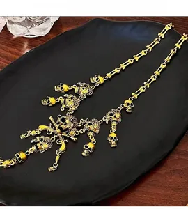 Detailed view of gothic gold skull necklace with bone links and tiered fringe pendants