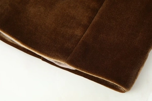 Detailed macro view showing the luxurious texture of dark brown velvet fabric and stitching