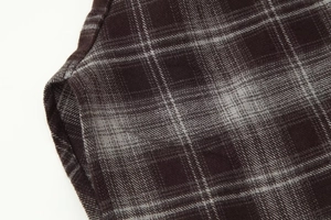 Macro shot of dark brown plaid twill fabric texture and tailored sewing details