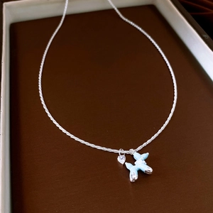 Détail du pendentif chien ballon bleu ciel et du zircon coeur sur chaîne argentée