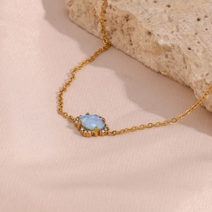 Detail of 18K gold petal bracelet with blue opal and crystals on pink silk fabric