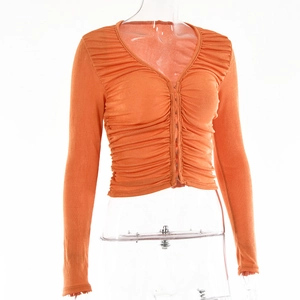 Détail du cardigan orange à col en V avec fronces, fermeture à crochets et manches longues