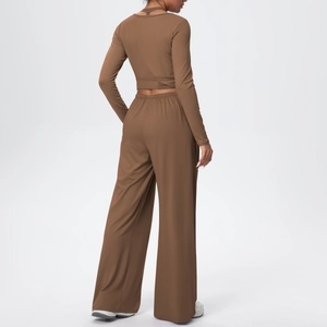 Détail d'un ensemble de yoga marron avec dos nu à lacets et pantalon large à taille haute