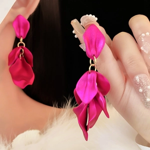 Vue détaillée des boucles d'oreilles pétales magenta mat au design floral étagé