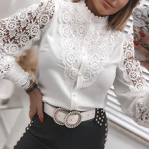 Detail of white long sleeve shirt showing intricate lace patchwork and button closure