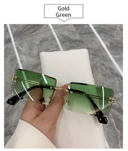 Detail view of gold metal temples and green gradient lenses on rimless sunglasses