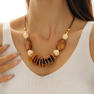 Close-up of vintage leather cord necklace with multi-shaped acrylic beads on model