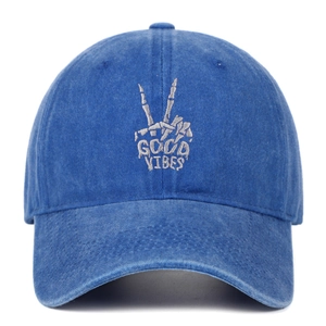 Close-up of skeleton hand embroidery and Good Vibes text on blue washed baseball cap
