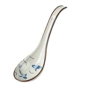 Japanese ceramic soup spoon with blue fish pattern and long handle on white background
