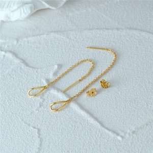 Macro shot of S925 sterling silver golden tassel earrings with elegant water drop pendants
