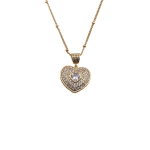 Macro shot of gold heart pendant necklace featuring sparkling cubic zirconia stones