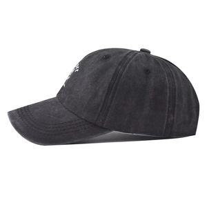 Detail of washed cotton baseball cap with white embroidery and vintage distressed texture