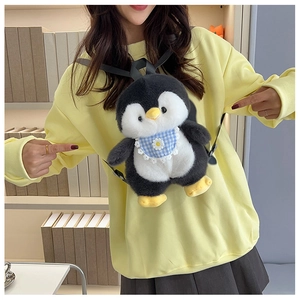 Detail of cute plush penguin backpack featuring a blue checkered daisy scarf on model