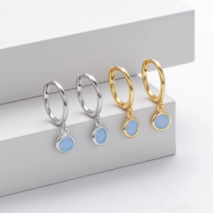Close-up of S925 sterling silver hoop earrings with round light blue opal stone charms