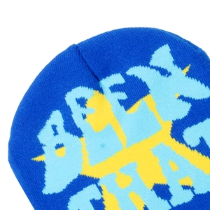Détail du tissage en maille et des lettres pixelisées bleues et jaunes sur le bonnet tricoté