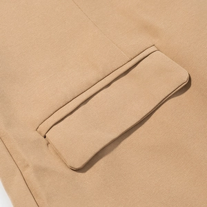 Macro del dettaglio della tasca a patta su cappotto di lana beige in twill