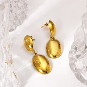 Polished gold stainless steel double oval drop earrings on minimalist white background