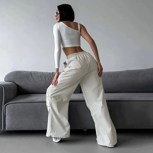 Dettaglio dei pantaloni cargo a vita alta e del crop top monospalla sulla modella