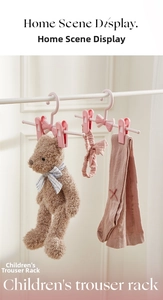 Detailed view of pink non-slip kids hangers with clips holding plush toys and accessories