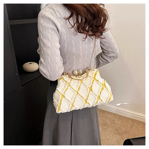 Close-up of yellow and white plaid shell bag with pearl clasp and chain strap
