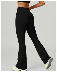 Détail d'un pantalon de yoga évasé à taille haute avec poches et effet amincissant