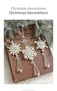 Detail of white glitter acrylic snowflake pendants with prism drops on pine branches