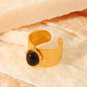 Macro detail of vintage gold steel ring featuring tiger eye stone and braided texture