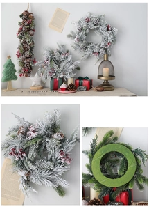 Détail d'une couronne de Noël givrée avec baies rouges, pommes de pin et aiguilles de pin