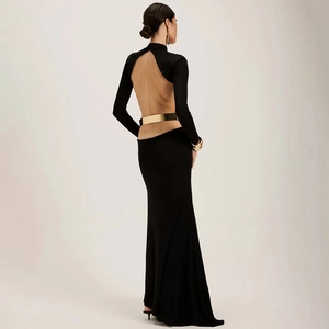 Détail d'une robe longue noire dos nu avec manches longues et ceinture en métal doré élégante