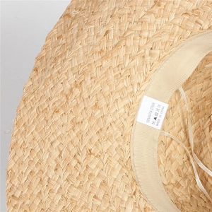Close-up of natural raffia straw weave with cotton sweatband and care label