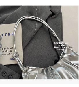 Detail of silver metallic dumpling bag with pleats and knotted handle decoration