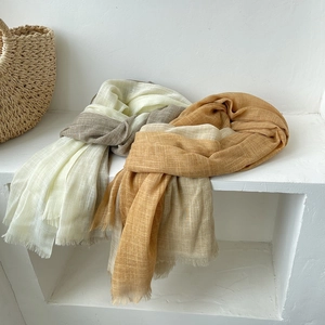 Detailed texture of cotton linen scarves in beige and khaki with soft fringe edges