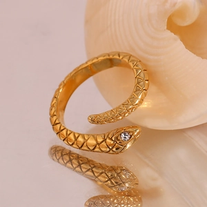 Macro shot of gold snake ring with realistic scale texture and sparkling crystal eye
