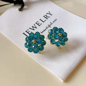 Detailansicht blumenförmiger Ohrstecker mit blauen Kristallen und Vergoldung am Rand