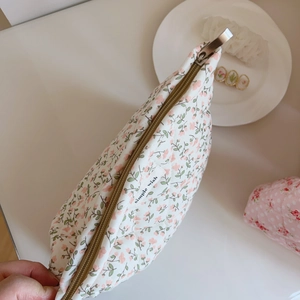 Gros plan sur la trousse à maquillage matelassée à fleurs roses avec fermeture en laiton