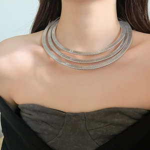 Detailed close-up of a silver triple-layered spring choker necklace on a female neck