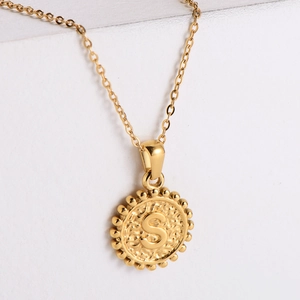 Macro view of 18k gold plated stainless steel necklace with relief letter S pendant