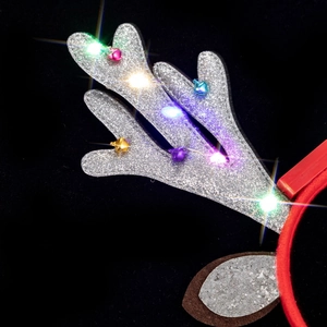 Detail of LED glowing reindeer antlers with colorful bells on festive headband