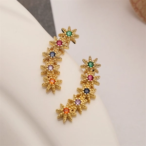 Detail of gold-plated star earrings featuring vibrant multi-colored gemstones in a row