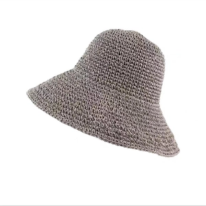 Dettaglio del cappello di paglia color talpa con trama intrecciata e tesa larga