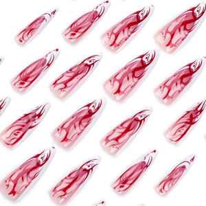 French stiletto false nails with red flame ombre design on nude base, almond shape