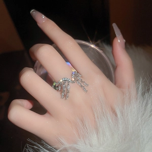 Detail of silver tassel ring with marquise cut zircon stones worn on model hand